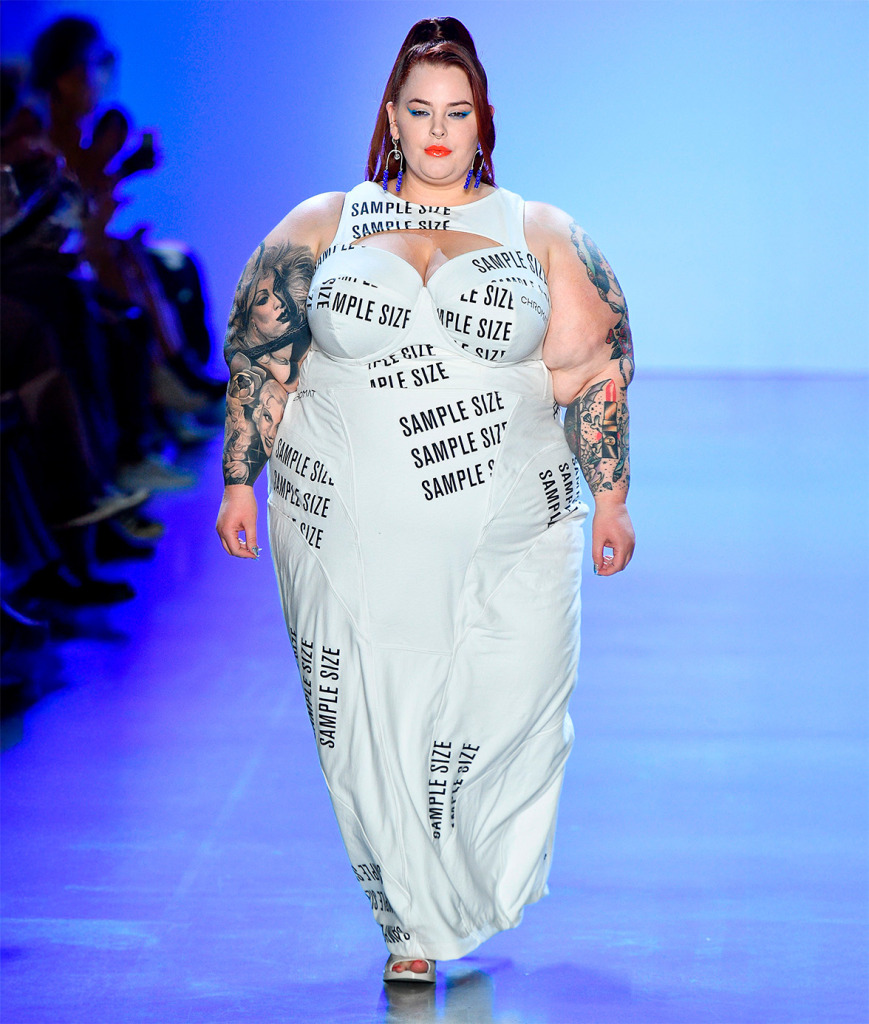 Tess Holliday défile en robe blanche imprimée «Sample Size» pour Chromat en 2019, tatouages visibles, attitude forte.